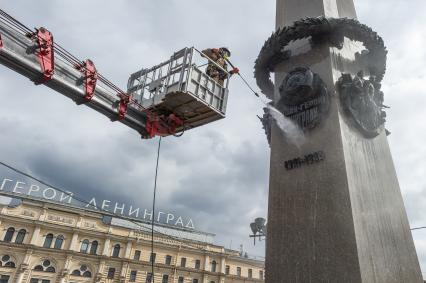 Санкт-Петербург. Сотрудник коммунальной службы моет  обелиск `Городу-герою Ленинграду` на площади Восстания.