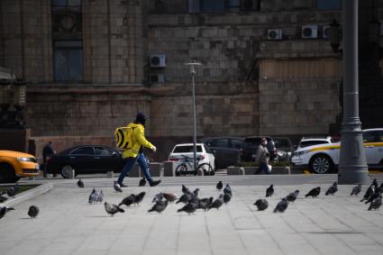 Москва. Сотрудник сервиса доставки `Яндекс. Еда`  на одной из улиц города.