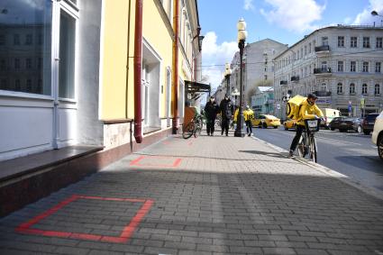 Москва. Сотрудник сервиса доставки `Яндекс. Еда` и  сотрудники полиции  на одной из улиц города.