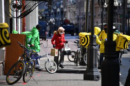 Москва. Сотрудники сервиса доставки  Delivery Club  и  `Яндекс. Еда`  на одной из улиц города.