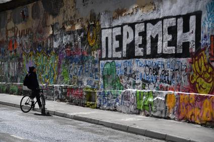 Москва. Молодой человек на велосипеде у стены Цоя на Арбате.