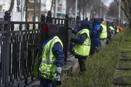 Екатеринбург. Рабочие службы городского благоустройства красят ограждение на улице