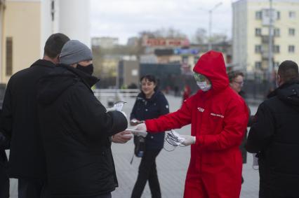 Екатеринбург. Волонтеры на ЖД Вокзале раздают пассажирам защитные маски, во время режима самоизоляции, введенного для нераспространения COVID-19. Указом губернатора Свердловской области Евгения Куйвашева, на территории региона с 1 по 11 мая 2020 будет введен \'Масочный режим\', во время которого в помещениях и общественном транспорте можно будет находиться только в защитной маске