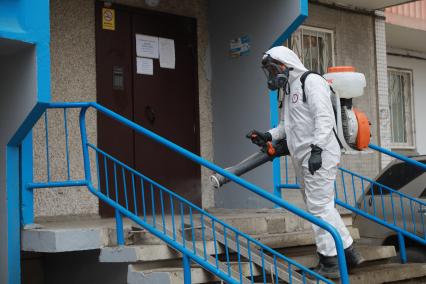 Красноярск. Сотрудник коммунальных служб проводит дезинфекцию подъездов жилых домов.