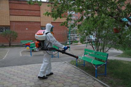 Красноярск. Сотрудник коммунальных служб проводит дезинфекцию детской площадки во дворе жилых домов.
