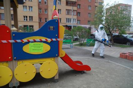 Красноярск. Сотрудник коммунальных служб проводит дезинфекцию детской площадки во дворе жилых домов.