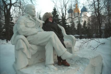 Москва. Женщина фотографируется рядом с памятником Ленину.