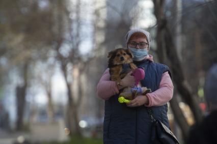 Екатеринбург. Женщина в медицинской маске с собачкой на руках во время режима самоизоляции введеного для нераспространения коронавирусной инфекции COVID-19