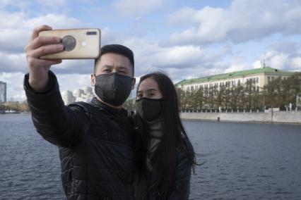 Екатеринбург. Парень с девушкой фотографируются на набережной реки Исеть во время масочного режима введеного для нераспространения коронавирусной инфекции COVID-19