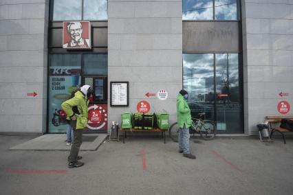 Екатеринбург. Курьеры служб доставки еды у ресторана KFC в ожидании заказа. Из-за эпидемии коронавирусной инфекции COVID-19 и введеного режима самоизоляции, рестораны стали работать \'на вынос\'