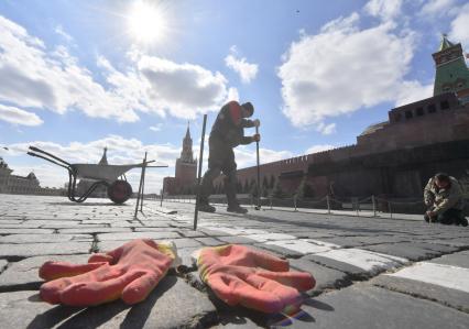 Москва. Рабочий ремонтирует брусчатку на Красной площади.