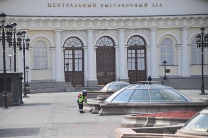 Москва. Сотрудник коммунальных служб подметает площадь.