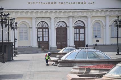 Москва. Сотрудник коммунальных служб подметает  площадь.