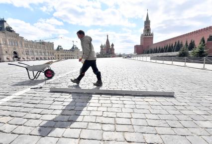 Москва. Рабочий ремонтирует брусчатку на Красной площади.