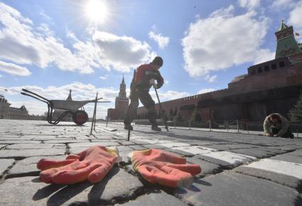 Москва. Рабочий ремонтирует брусчатку на Красной площади.