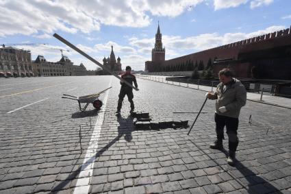 Москва. Рабочие ремонтируютт брусчатку на Красной площади.