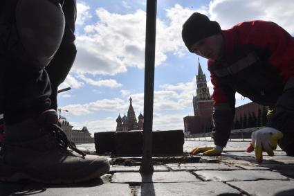 Москва. Рабочие ремонтируютт брусчатку на Красной площади.