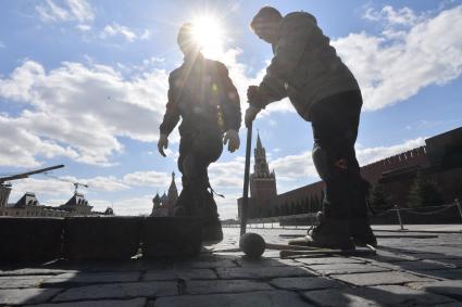 Москва. Рабочие ремонтируютт брусчатку на Красной площади.