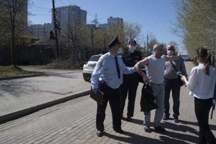 Екатеринбург. Сотрудники полиции сопровождают мужчину задержаного на пляже, за нарушение режима самоизоляции введеного для нераспространения новой коронавирусной инфекции COVID-19