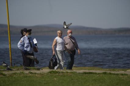 Екатеринбург. Сотрудники полиции сопровождают мужчину задержаного на пляже, за нарушение режима самоизоляции введеного для нераспространения новой коронавирусной инфекции COVID-19