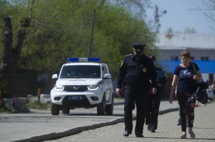 Екатеринбург. Сотрудники полиции сопровождают женщину задержаную на пляже, за нарушение режима самоизоляции введеного для нераспространения новой коронавирусной инфекции COVID-19