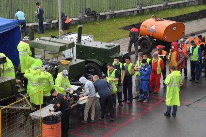 Москва.  Рабочие стоят в очереди за едой на стройплощадке временного госпиталя для лечения пациентов с коронавирусной инфекцией в ледовом дворце `Крылатское`.