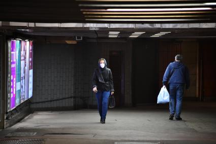 Москва. Женщина в медицинской маске в подземном переходе.