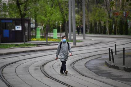 Москва. Молодой человек в медицинской маске на улице.