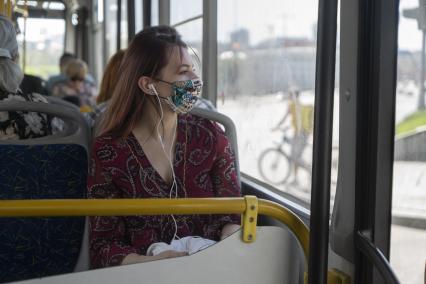 Екатеринбург. Девушка в защитной маске в автобусе. В Свердловской области с 1 мая 2020г введен \'Масочный режим\', когда в общественном транспорте и замкнутых пемещениях обязательно находиться в медицинской или защитной маске. Режим самоизоляции для нераспространения новой коронавирусной инфекции COVID-19