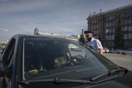 Екатеринбург. Сотрудники ГИБДД вручают водителю светоотражающие значки  наклейки с символикой 75-й годовщины Победы, накануне Дня Победы