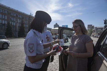 Екатеринбург. Сотрудники ГИБДД вручают водителю светоотражающие значки  наклейки с символикой 75-й годовщины Победы, накануне Дня Победы