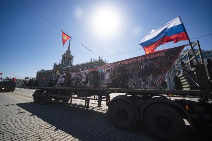 Екатеринбург. Горожане наблюдают за прохождением колонны военных грузовиков с платформами-баннерами с изображением основных этапов Великой Отечественной войны, на проспекте Ленина во время праздничных мероприятий в честь 75-й годовщины победы в ВОВ, во время режима самоизоляции введеного для нераспространения новой коронавирусной инфекции COVID-19