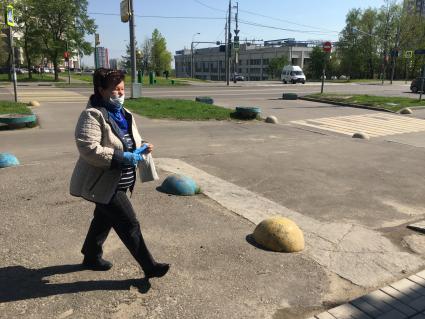 Москва. Женщина в медицинской маске и перчатках на улице города.