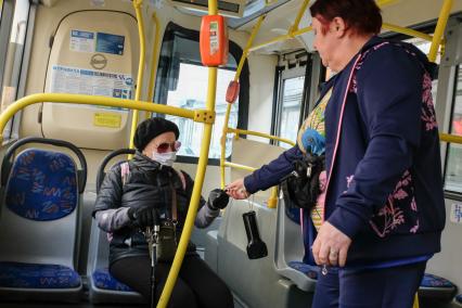 Санкт-Петербург.  Пожилая женщина в медицинской маске в автобусе.