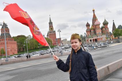 Москва. Девочка с красным флагом и  военной пилотке  на Васильевском спуске  во время воздушного парада Победы в Москве.