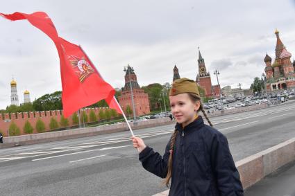 Москва. Девочка с красным флагом и  военной пилотке  на Васильевском спуске  во время воздушного парада Победы в Москве.