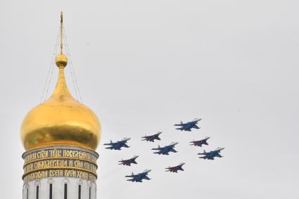 Москва. Истребители МиГ-29 и Су-30СМ пилотажных групп Русские витязи и Стрижи во время воздушного парада Победы в Москве.