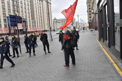 Москва.  Мужчина с красным флагом и сотрудники полиции  во время празднования дня Победы.