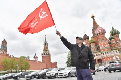 Москва.  Мужчина с красным флагом на Васильевском спуске во время празднования дня Победы.