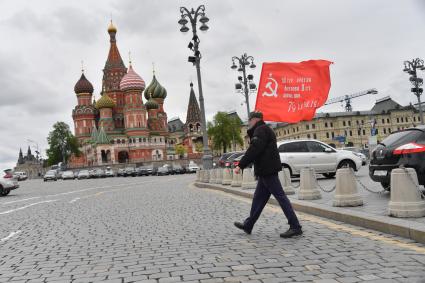 Москва.  Мужчина с красным флагом на Васильевском спуске во время празднования дня Победы.