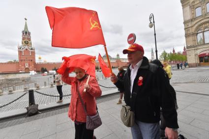 Москва. Прохожие с красными флагами на Красной площади во время празднования Дня Победы.