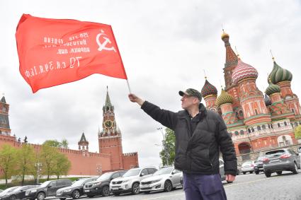 Москва.  Мужчина с красным флагом на Васильевском спуске во время празднования дня Победы.