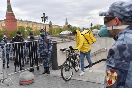 Москва.  Сотрудник сервиса доставки еды на Манежной площади.