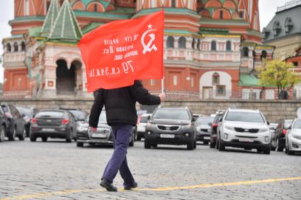 Москва.  Мужчина с красным флагом на Васильевском спуске во время празднования дня Победы.