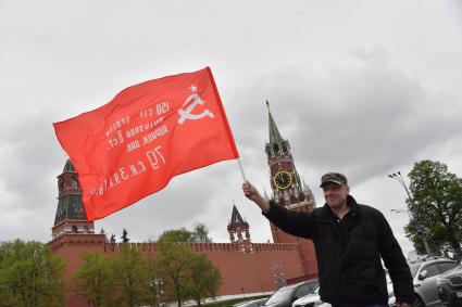 Москва.  Мужчина с красным флагом на Васильевском спуске во время празднования дня Победы.