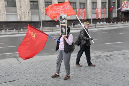 Москва.  Прохожие  с портретами своих родственников - участников Великой Отечественной войны  и красными флагами во время празднования дня Победы.