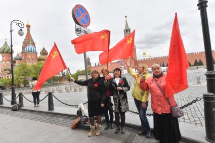 Москва. Женщины с красными флагами на Красной площади во время празднования Дня Победы.