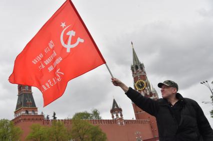 Москва.  Мужчина с красным флагом на Васильевском спуске во время празднования дня Победы.