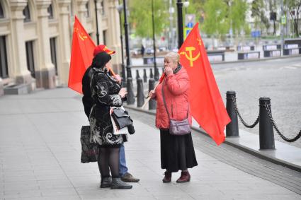 Москва. Прохожие с красными флагами на Красной площади во время празднования Дня Победы.