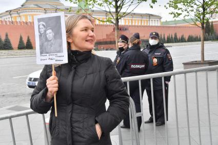 Москва.  Женщина  с портретом родственника - участника Великой Отечественной войны на Красной площади во время празднования дня Победы.